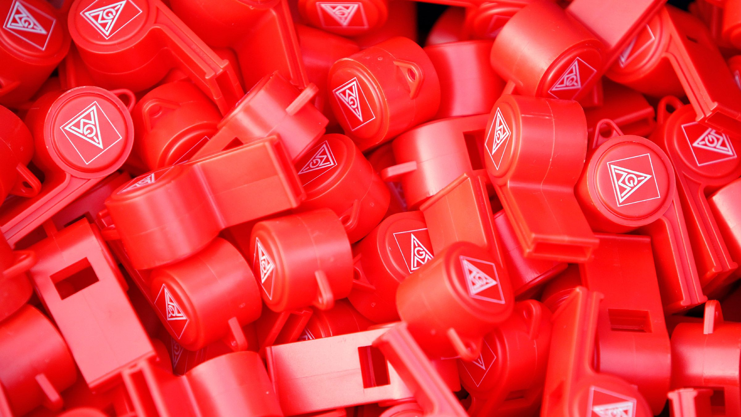 Viele rote Trillerpfeifen mit dem Logo der IG Metall.